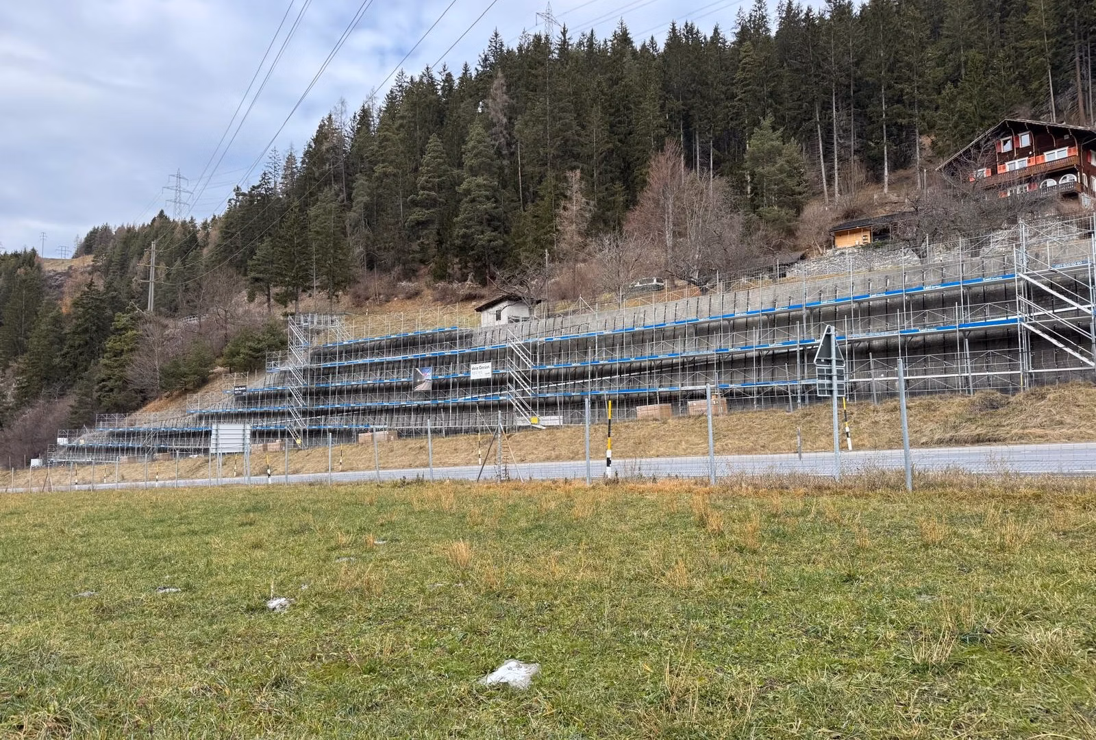 Gerüst und Montagestruktur entlang der Stützmauer oberhalb der Julierstrasse, vorbereitet für die Installation der PV-Module.