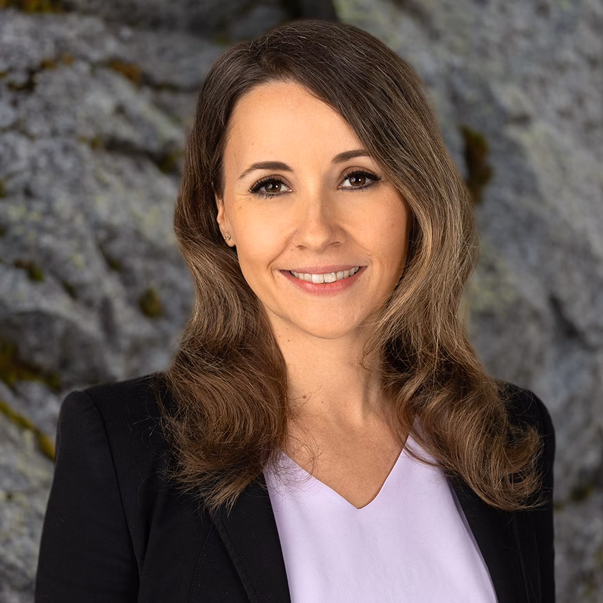 Portrait of a woman in a black blazer in front of a rock face