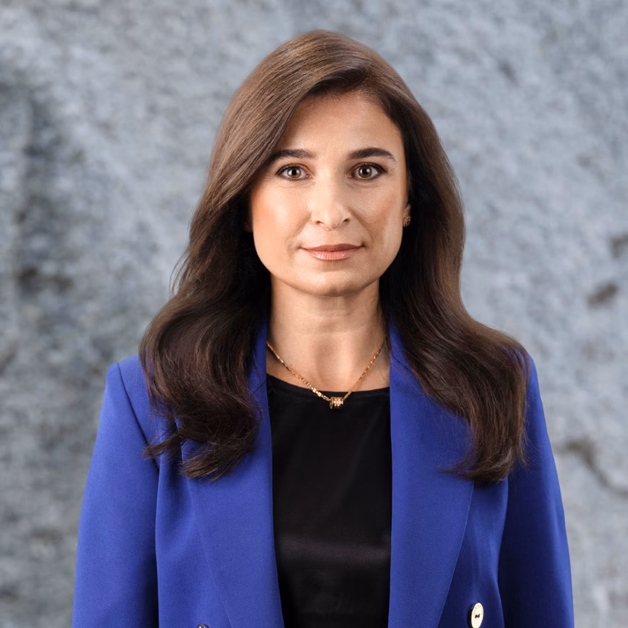 Portrait of a woman in a blue blazer against a grey background